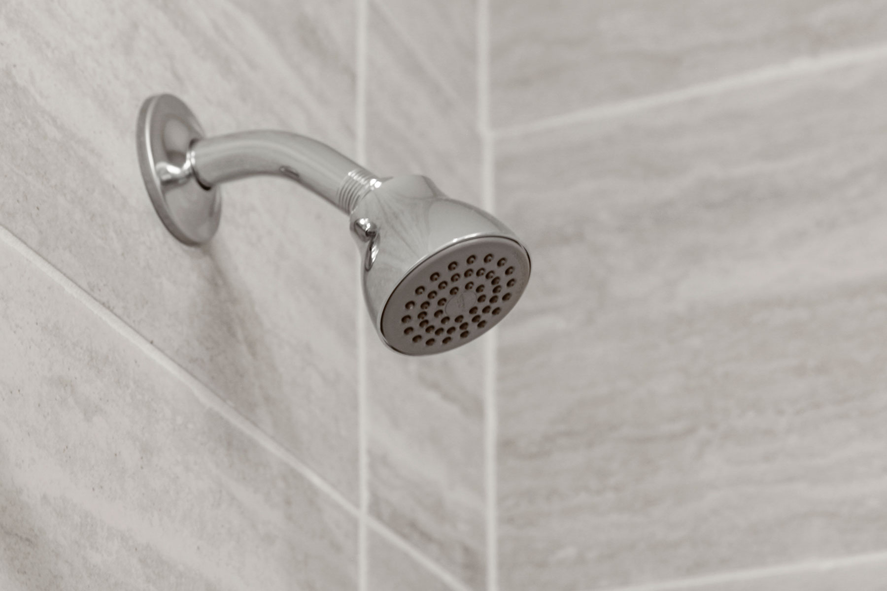 Detail of chrome showerhead and tiles